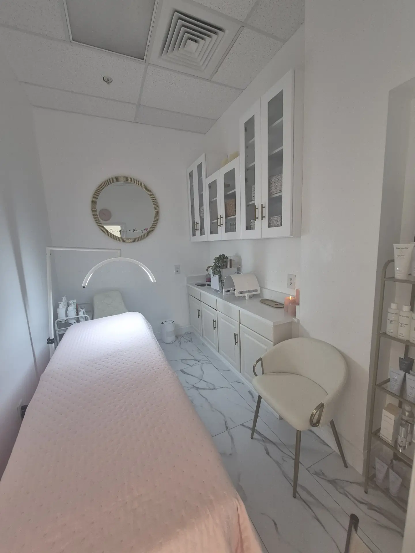 Palm Beach Skin Co. treatment room in Loxahatchee with a facial bed, ring light and skincare shelf